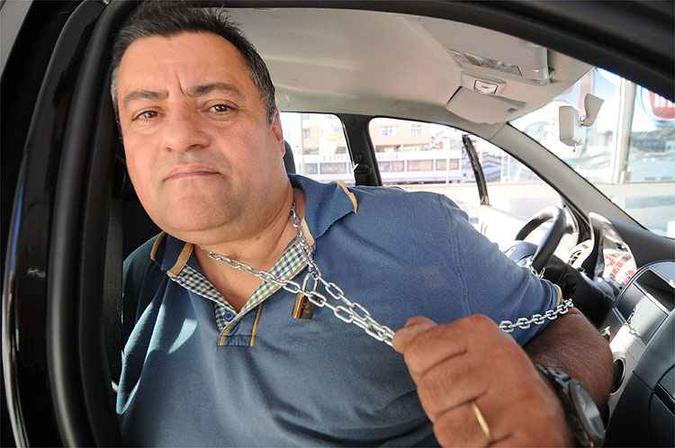Fábio Freitas se acorrentou a um Fiat Palio Fire exposto na loja para chamar a atenção de autoridades(foto: Beto Novaes/EM/D.A Press) Fábio Freitas se acorrentou a um Fiat Palio Fire exposto na loja para chamar a atenção de autoridades(foto: Beto Novaes/EM/D.A Press)
