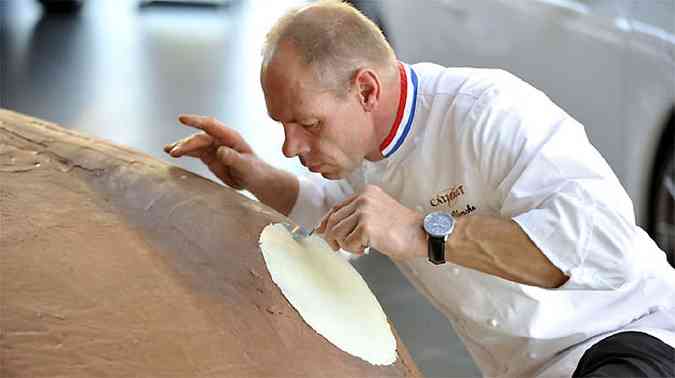 Chef d o toque final no Porsche coberto com 175 kg de puro chocolate ao leite e detalhes em chocolate branco(foto: Porsche/Divulgao)